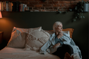 Sad woman lying on one side of a double bed